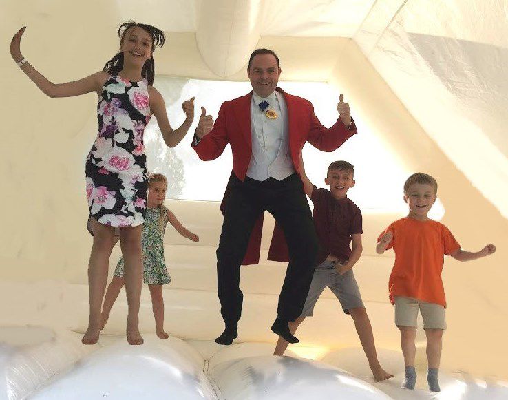 Gallery of the Professional Toastmasters - family on a bouncy castle at a wedding